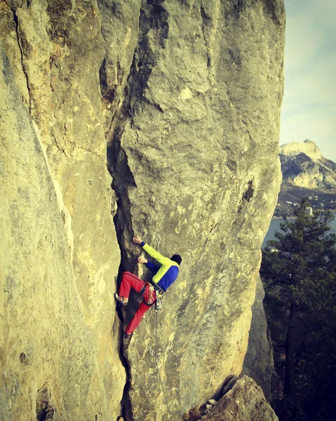 Arka planda geniş Vadisi ile kireçtaşı duvara tırmanma sallamak Climber.Young adam
