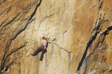 Arka planda geniş Vadisi ile kireçtaşı duvara tırmanma sallamak Climber.Young adam