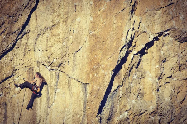 Escalador de rocas.Joven escalando en una pared de piedra caliza con amplio valle en el fondo — Foto de Stock