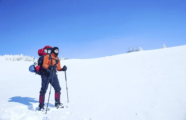 Senderismo de invierno en las montañas en raquetas de nieve con una mochila y tienda de campaña . — Foto de Stock