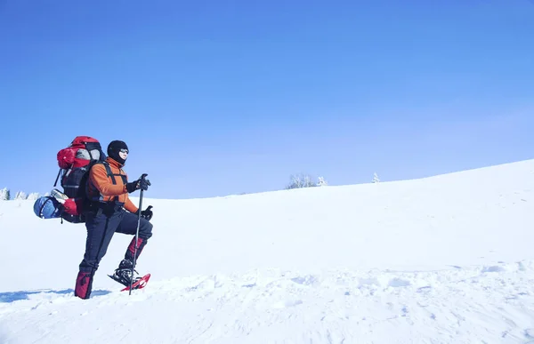 Senderismo de invierno en las montañas en raquetas de nieve con una mochila y tienda de campaña . —  Fotos de Stock