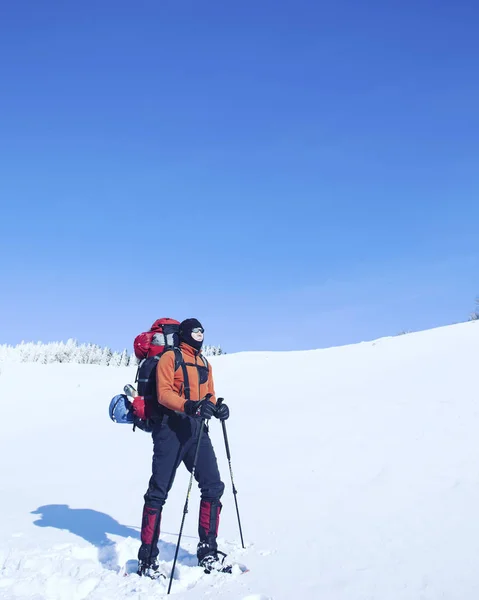 Senderismo de invierno en las montañas en raquetas de nieve con una mochila y tienda de campaña . — Foto de Stock