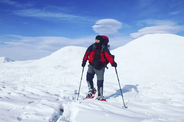 Vinter vandring. Vintern vandra i bergen på snöskor med en ryggsäck och tält. — Stockfoto