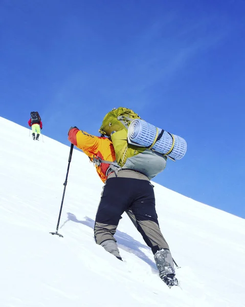 Hiking kış. Dağlarda kar ayakkabıları bir sırt çantası ve çadır hiking kış. — Stok fotoğraf