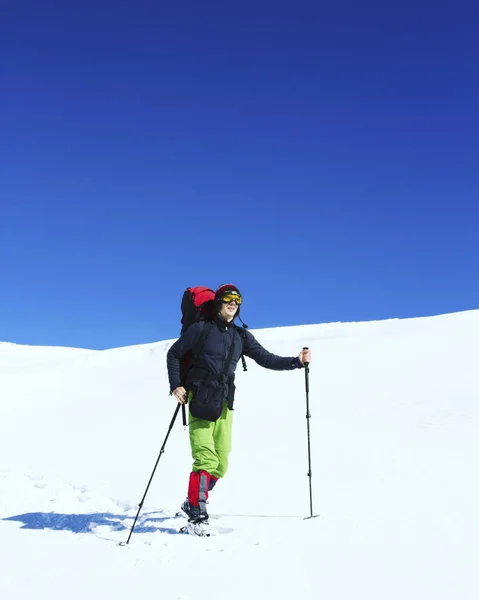 Randonnée hivernale.Randonnée hivernale en montagne en raquettes avec sac à dos et tente . — Photo