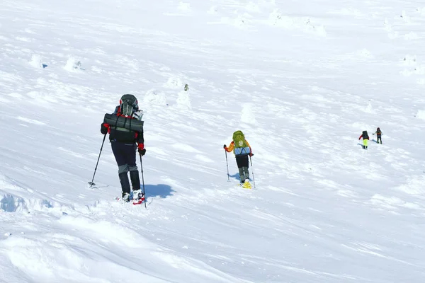 Hiking kış. Dağlarda kar ayakkabıları bir sırt çantası ve çadır hiking kış. — Stok fotoğraf