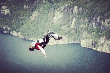 Rope jumping.Jump off a cliff into a canyon with a rope. clipart