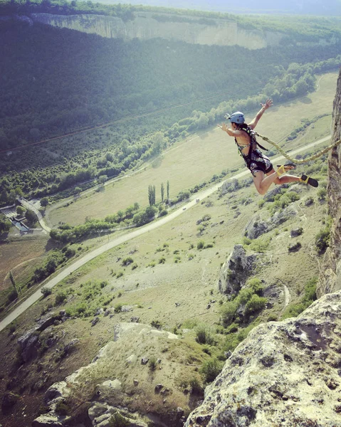 Saltar de un acantilado a un cañón con una cuerda . — Foto de Stock