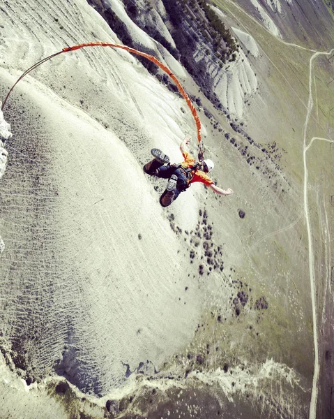 Rep hoppande. Hoppa från en klippa i en kanjon med ett rep. — Stockfoto