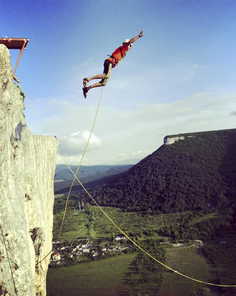 Sauter d'une falaise dans un canyon avec une corde . — Photo