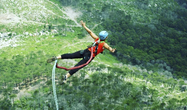 ロープ ジャンプします。ロープを使って渓谷に崖から飛び降りる. — ストック写真