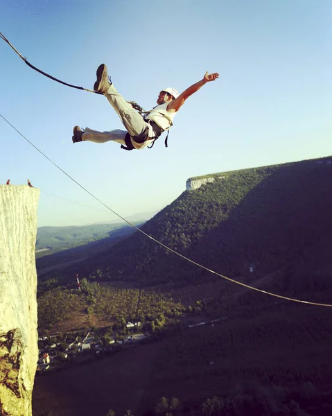 Rope jumping.Jump off a cliff into a canyon with a rope.