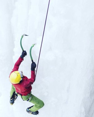 Buz tırmanışı. Adam buz aracıyla donmuş bir şelale.