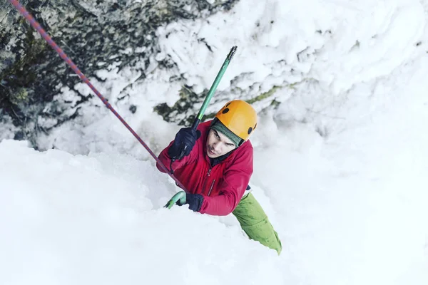 Escalada no Gelo.Homem escalando uma cachoeira congelada com ferramenta de gelo . — Fotografia de Stock