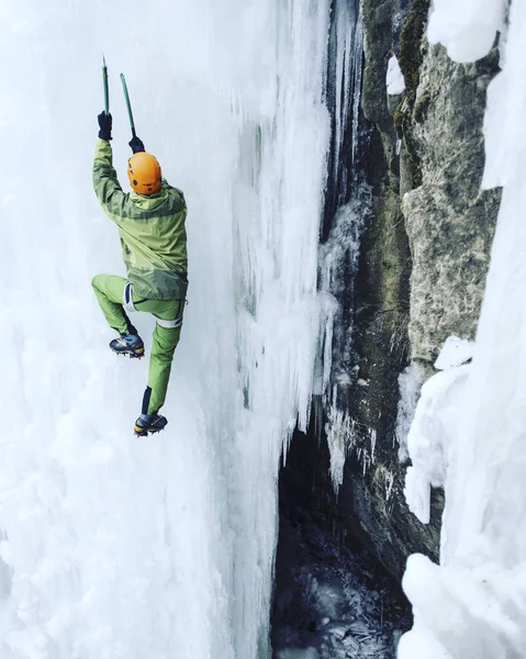 Jég mászás. Férfi hegymászó egy fagyasztott vízesés ice eszközzel. — Stock Fotó