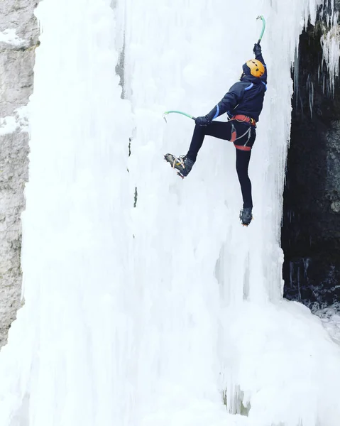 Escalada no Gelo.Homem escalando uma cachoeira congelada com ferramenta de gelo . — Fotografia de Stock