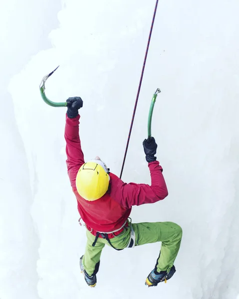 Ice climbing.Man climbing a frozen waterfall with ice tool. — Stock Photo, Image