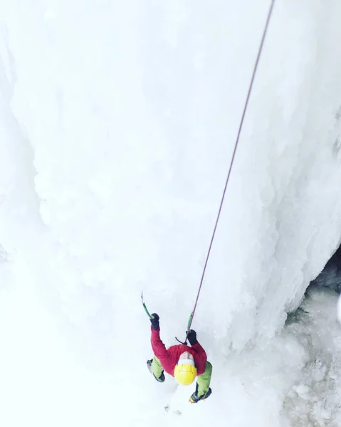 Escalada de hielo.Hombre escalando una cascada congelada con herramienta de hielo . —  Fotos de Stock