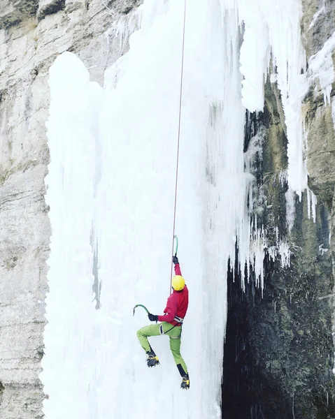 Buz tırmanışı. Adam buz aracıyla donmuş bir şelale. — Stok fotoğraf