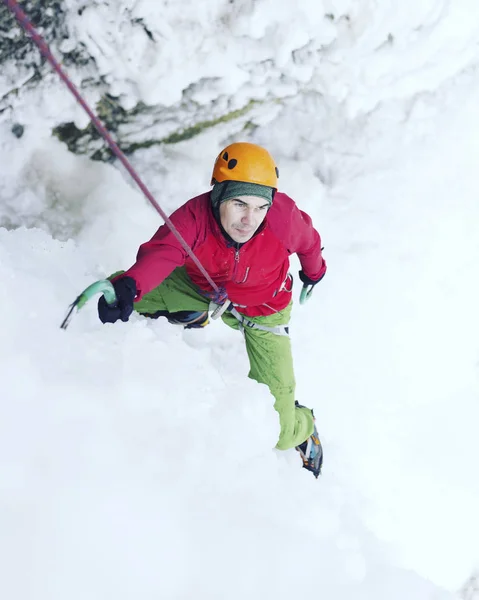 Jég mászás. Férfi hegymászó egy fagyasztott vízesés ice eszközzel. — Stock Fotó