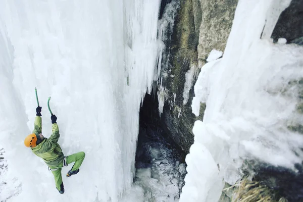 Escalada de hielo.Hombre escalando una cascada congelada con herramienta de hielo . —  Fotos de Stock