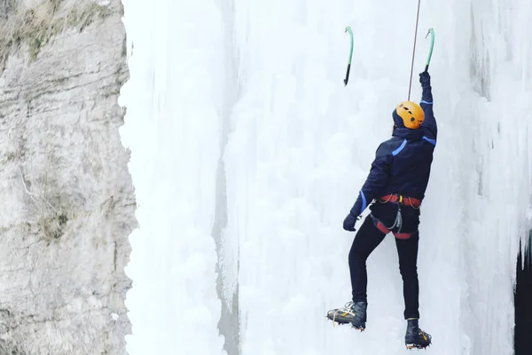 Escalada no Gelo.Homem escalando uma cachoeira congelada com ferramenta de gelo . — Fotografia de Stock