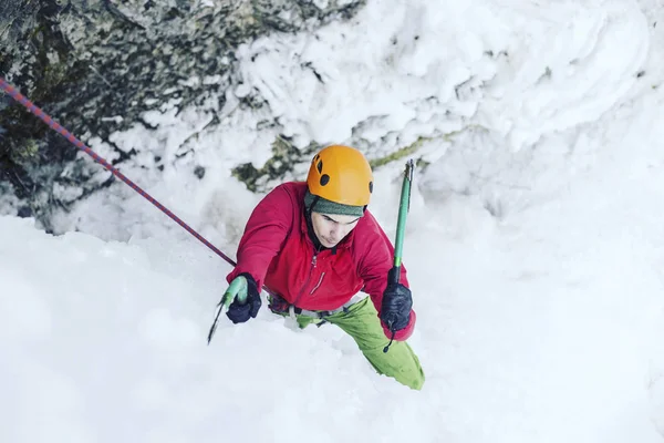 Escalada no Gelo.Homem escalando uma cachoeira congelada com ferramenta de gelo . — Fotografia de Stock