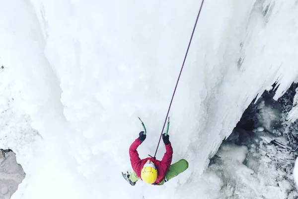 Ice climbing.Man climbing a frozen waterfall with ice tool. — Stock Photo, Image