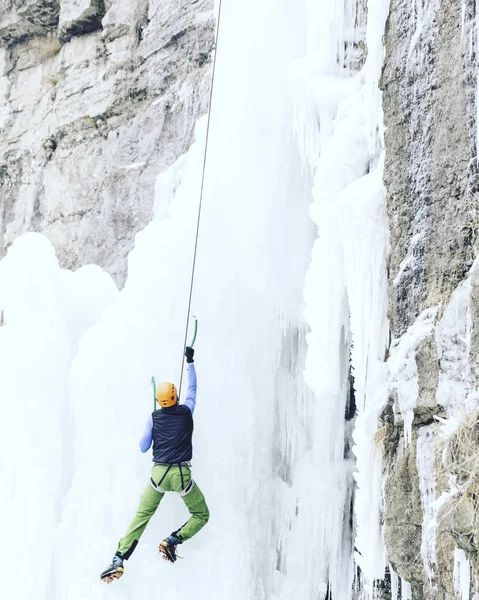 Escalada no Gelo.Homem escalando uma cachoeira congelada com ferramenta de gelo . — Fotografia de Stock