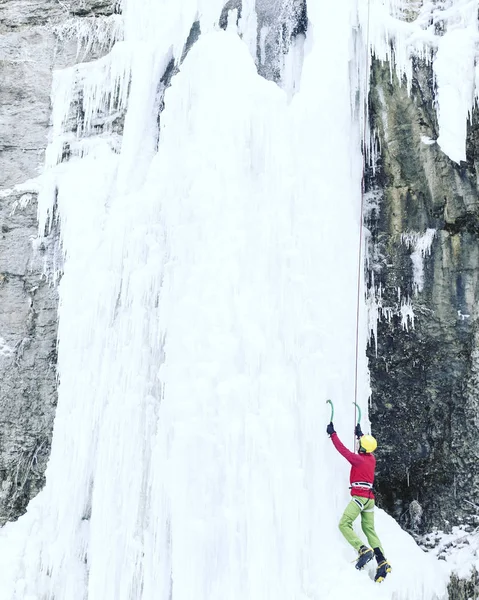 Escalada no Gelo.Homem escalando uma cachoeira congelada com ferramenta de gelo . — Fotografia de Stock