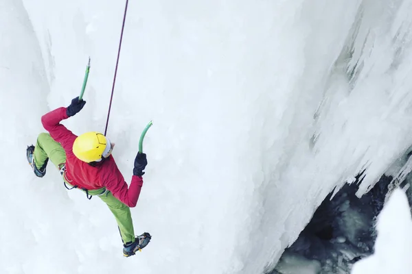 Escalade de glace.Homme escalade une cascade gelée avec outil de glace . — Photo