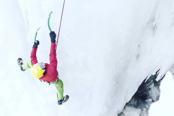 Jég mászás. Férfi hegymászó egy fagyasztott vízesés ice eszközzel. — Stock Fotó