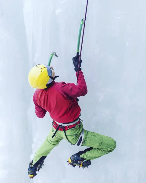 IJsklimmen. Man klimmen een bevroren waterval met ijs gereedschap. — Stockfoto