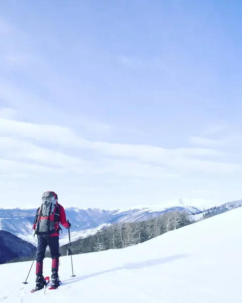 Caminhadas de inverno.Caminhadas de inverno nas montanhas em sapatos de neve com mochila e tenda . — Fotografia de Stock