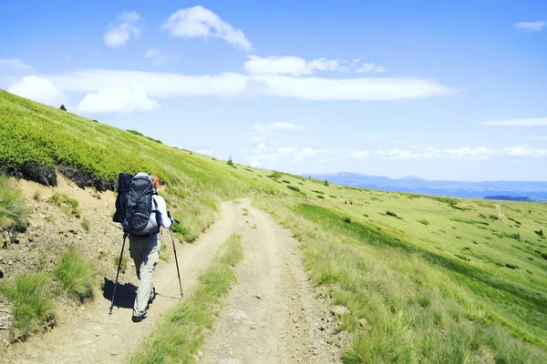 Senderismo de verano.Senderismo de verano en las montañas con una mochila y una tienda . — Foto de Stock