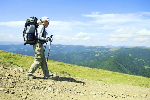 Senderismo de verano.Senderismo de verano en las montañas con una mochila y una tienda . — Foto de Stock