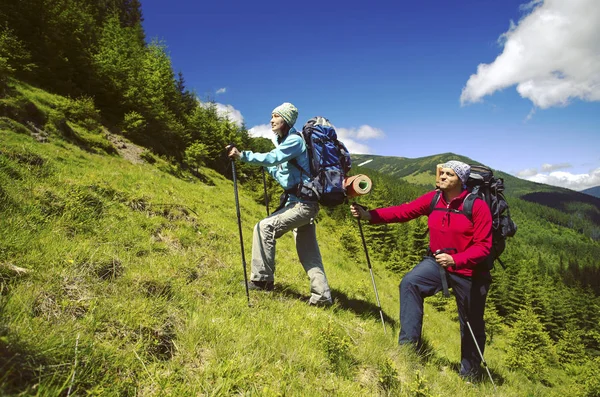 Senderismo de verano.Senderismo de verano en las montañas con una mochila y una tienda . — Foto de Stock