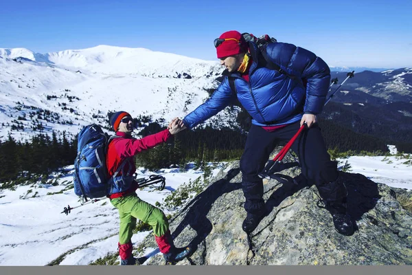 Senderismo de invierno en las montañas en raquetas de nieve con una mochila y — Foto de Stock