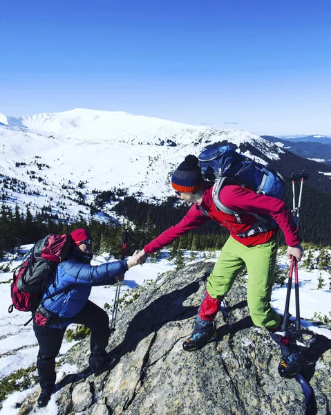 Senderismo de invierno en las montañas en raquetas de nieve con una mochila y — Foto de Stock