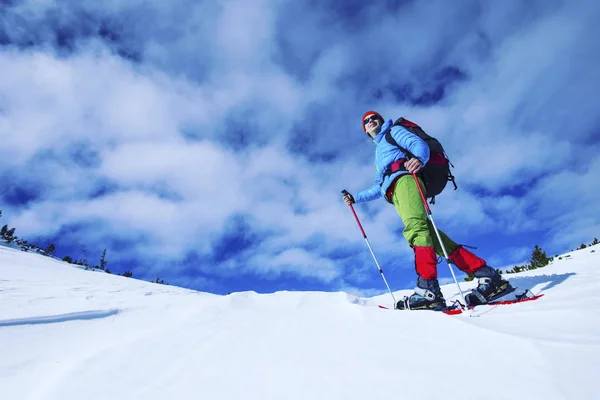 Vintern vandra i bergen på snöskor med en ryggsäck och — Stockfoto