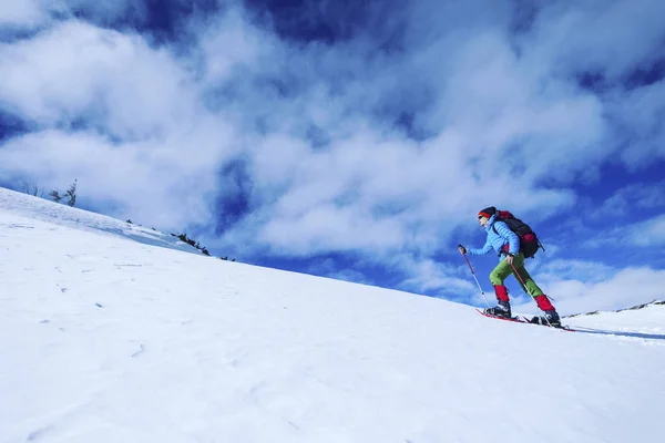 Senderismo de invierno en las montañas en raquetas de nieve con una mochila y — Foto de Stock