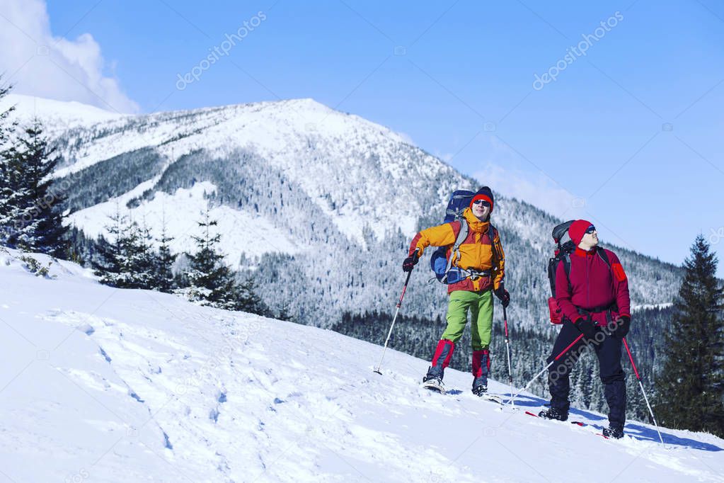 Winter hiking in the mountains on snowshoes with a backpack and 