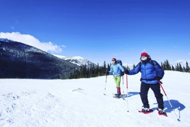 Dağlarda kar ayakkabıları bir sırt çantası ile hiking kış ve 