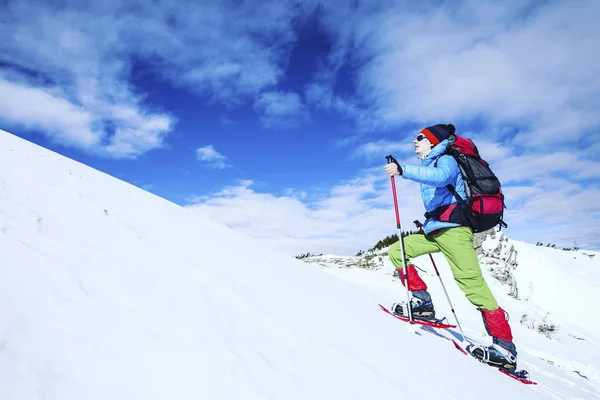 Zimní turistika v horách na sněžnicích s batohem a — Stock fotografie