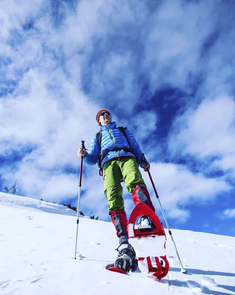 Senderismo de invierno en las montañas en raquetas de nieve con una mochila y — Foto de Stock