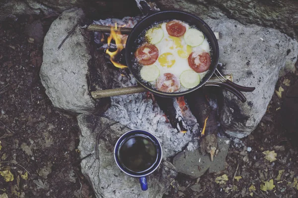 Cooking breakfast on a campfire at a summer camp.