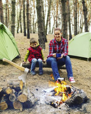 Ormanda kamp. Anne ve oğlu yangın öncesi oturuyorsun