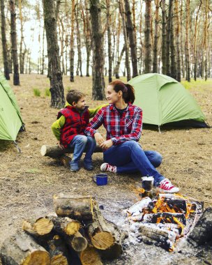 Ormanda kamp. Anne ve oğlu yangın öncesi oturuyorsun