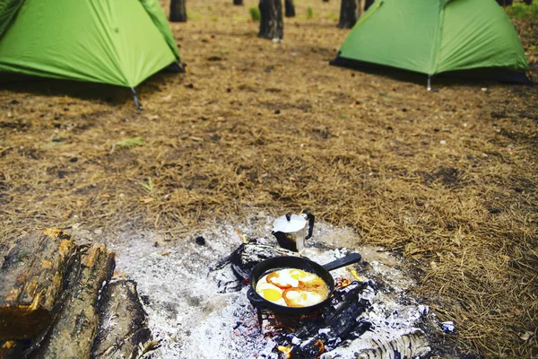 Camping in the forest. Preparation of breakfast at the stake. — Stock Photo, Image