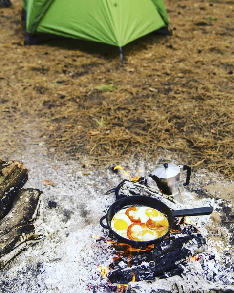 Camping in the forest. Preparation of breakfast at the stake. — Stock Photo, Image